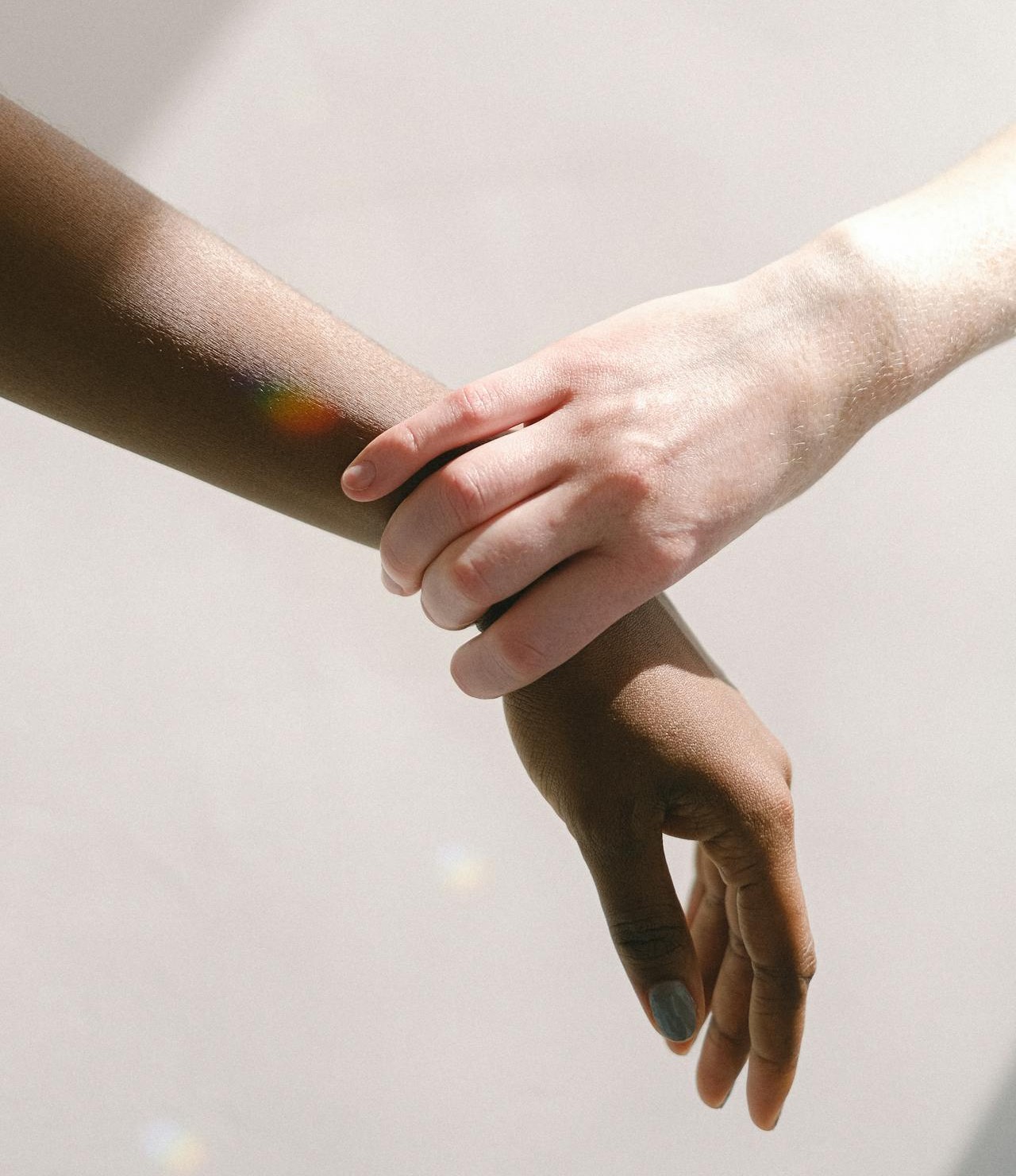 Hand holding wrist of another person's hand